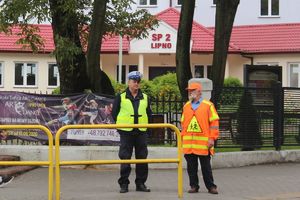 policjant z mężczyzną kierującym ruchem w obrębie szkoły