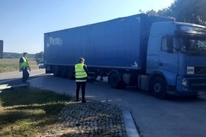 policjant z inspektorem zatrzymują ciężarówkę