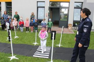 dziewczynka pod okiem policjantki przechodzi przez przejście dla pieszych