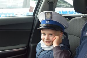 chłopiec w czapce policyjnej w radiowozie