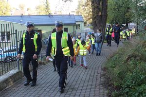 policjanci prowadzą dzieci przez park