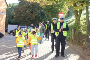 policjanci i dzieci idą parkiem