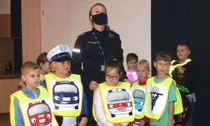 policjantka i dzieci w kamizelkach odblaskowych