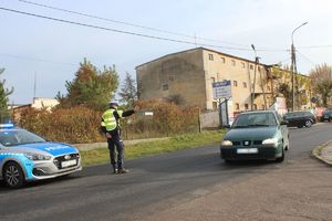 policjant kieruje auto na objazd