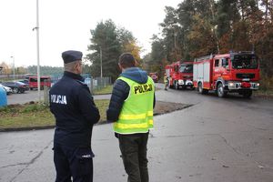 policjanci rozmawiają w tle wozy Straży Pożarnej