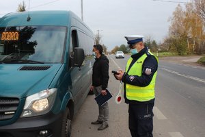 policjant i pracownik sanepidu kontrolują autobus