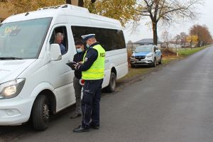 policjant i pracownik sanepidu rozmawiają z kierowcą