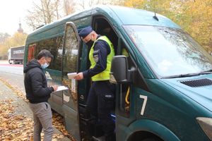 policjant wysiada z busa, obok pracownik sanepidu