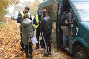 policjanci rozmawiają z kobietami przy busie