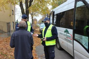 policjanci rozmawiają z mężczyzna przy busie