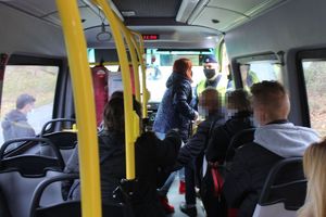 policjant rozmawia z pasażerami busa