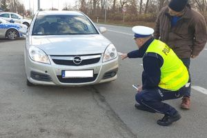 policjant kontroluje oświetlenie pojazdu