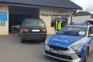 policjant przed stacją kontroli pojazdów