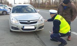 policjant kontroluje oświetlenie pojazdu