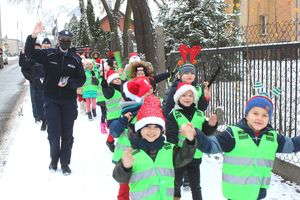 policjantka z dziećmi idzie chodnikiem