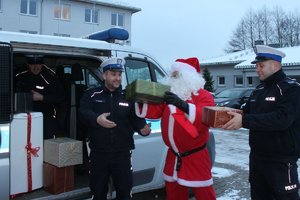 policjanci z Mikołajem wkładają paczki do auta
