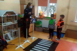 policjantka uczy dzieci przechodzić przez pasy