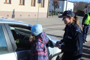 dziewczynka z policjantka wręcza kierowcy &quot;serduszko&quot;