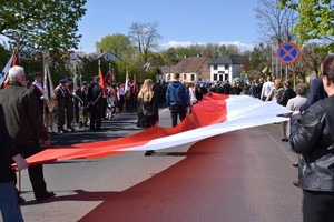 mieszkańcy niosą biało-czerwoną flagę