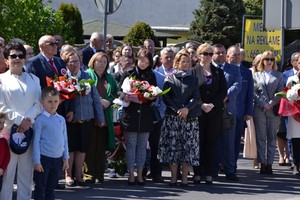 uczestnicy uroczystości z kwiatami