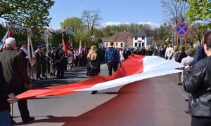 mieszkańcy niosący biało-czerwoną flagę