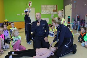 policjanci omawiają przypadek omdlenia w ramach ćwiczeń z wzywania pomocy i pierwszej pomocy