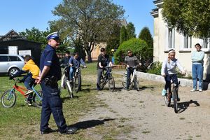 policjant obserwuje tor przeszkód w tle uczniowie czekający na swoją kolej