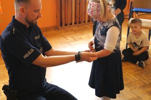 policjant wręcza dziewczynce odblask