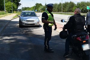 policjant rozmawia z kierowcą jednośladu