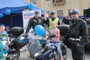 dziewczynka na motocyklu pozuje z policjantami