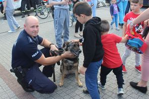 dzieci głaszczą psa policyjnego