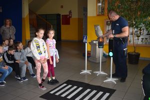 policjant uczy dzieci przekraczania jezdni