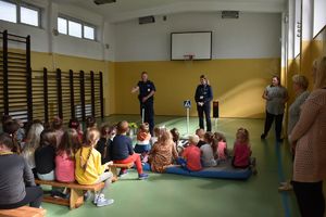 policjanci rozmawiają z dziećmi na sali gimnastycznej