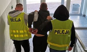 policjanci prowadzą zatrzymanego