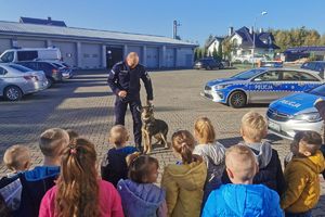 policjant z psem służbowym robi pokaz dla dzieci