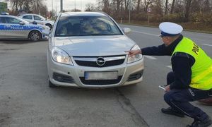 policjant kontroluje oświetlenie pojazdu