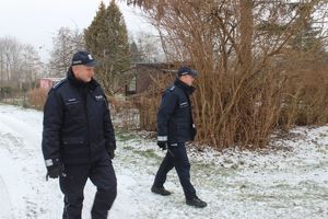 policjanci sprawdzają teren ogródków działkowych