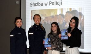 policjantki i uczennice z plakatami promującymi zawód policjanta