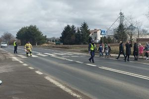 policjanci z uczniami na przejściu dla pieszych