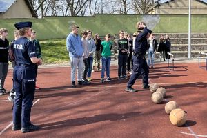 policjant pokazuje rzuty piłką lekarską