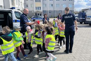 dzieci przybijają piątkę z policjantami