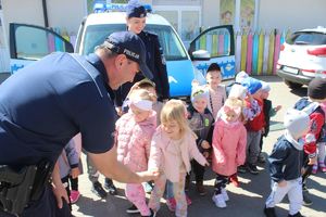 dzieci przybijają piątkę z policjantami