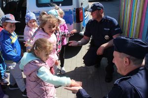 dzieci przybijają piątkę z policjantami