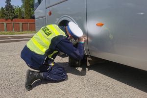 policjant kontroluje stan opon