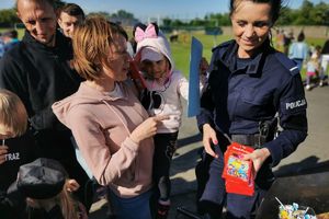 policjantka rozdaje dzieciom kredki