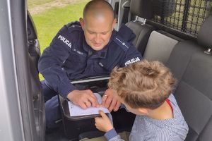 policjant robi chłopcu odbitki linii papilarnych