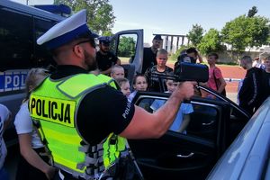 policjant pokazuje dzieciom miernik prędkości