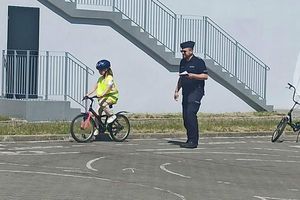 policjant sprawdza poprawność przejazdu dziecka na rowerze