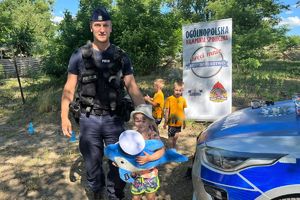 policjant z dziećmi przy radiowozie