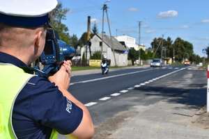 Policjant mierzy prędkość na drodze.